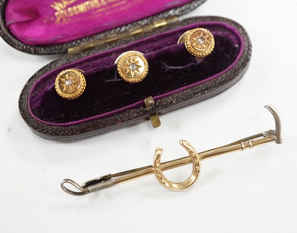 An Edwardian cased set of three 9ct and rose cut diamond set dress studs and a 9ct and silver riding crop and horseshoe bar brooch. Condition - fair